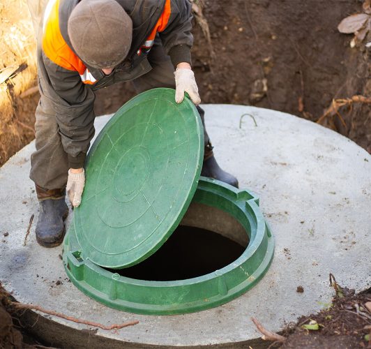 Man opening up septic tank cover