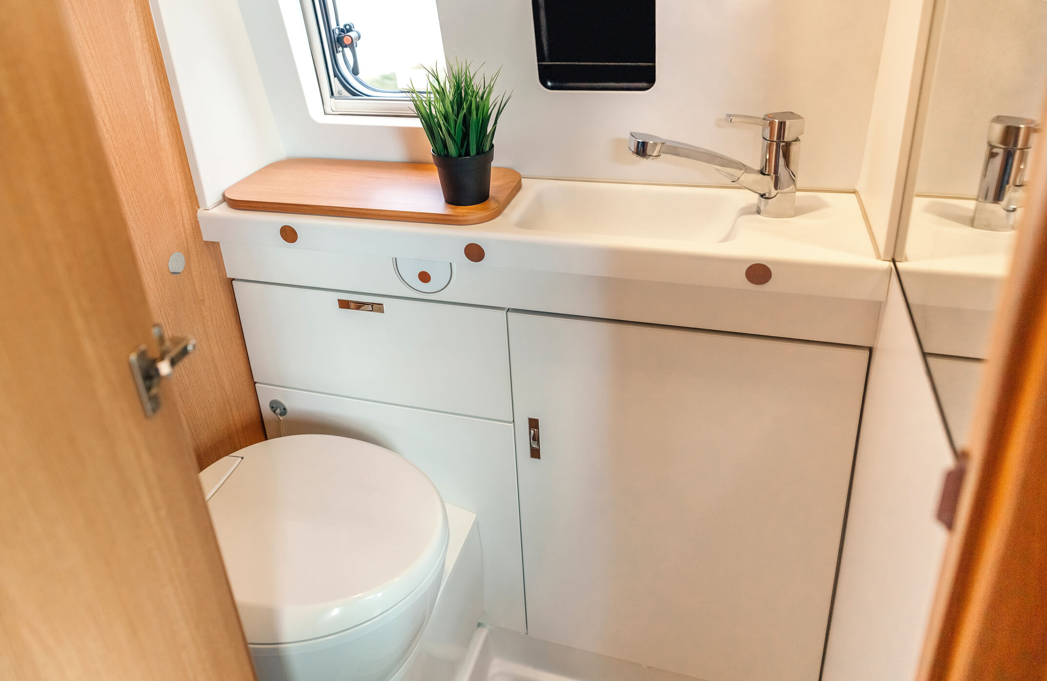 A modern toilet and sink inside a luxury restroom trailer